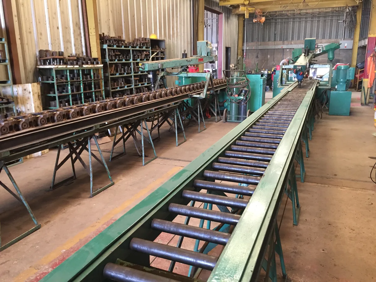 Track chain and roller line inside the Fresno Tractor undercarriage shop